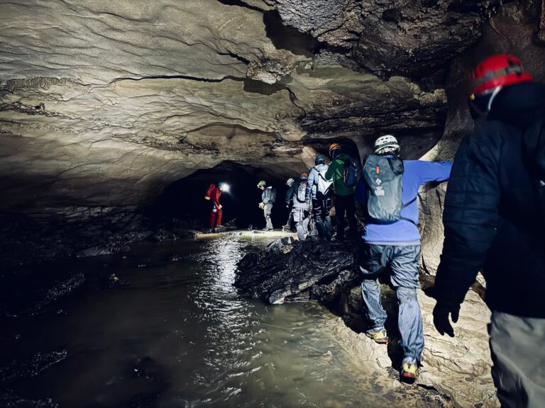 A rescue team moves through a flooded cave passage